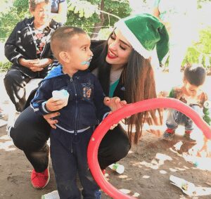 Miss Mexico with a kid at social work place