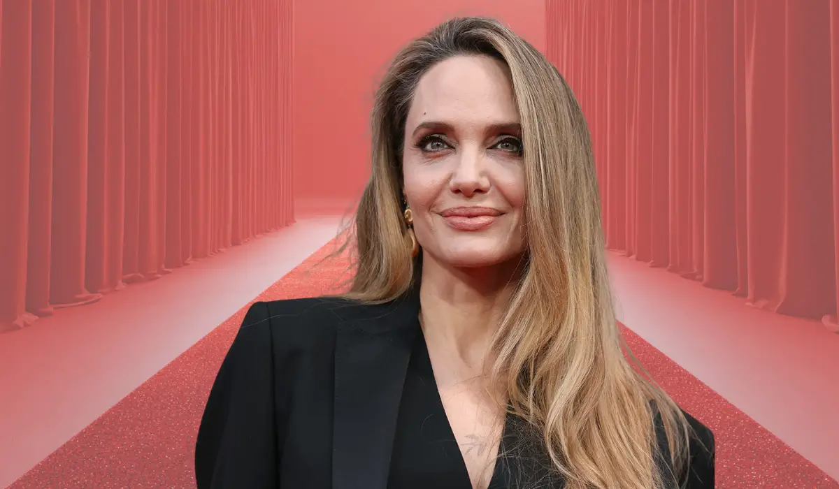 Portrait of a person standing on a red carpet with curtains in the background