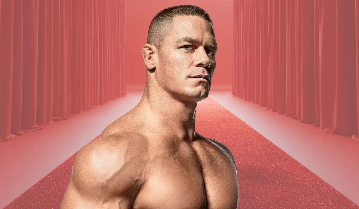 A muscular man posing on a red carpet backdrop
