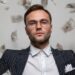 Well-dressed man standing confidently with money falling around him