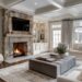 Bright modern living room with a stone fireplace, neutral furniture, large windows, and upscale interior design finishes