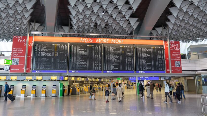 Passengers check flight information inside Frankfurt Airport's departure hall