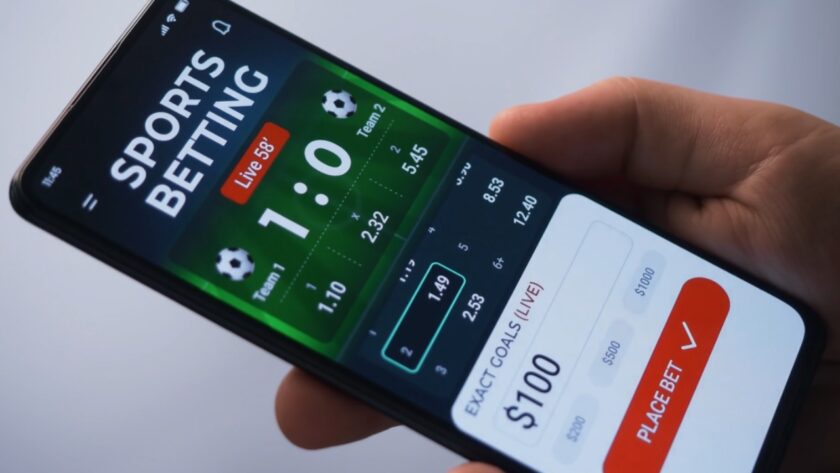 A person places a live sports bet on a mobile phone