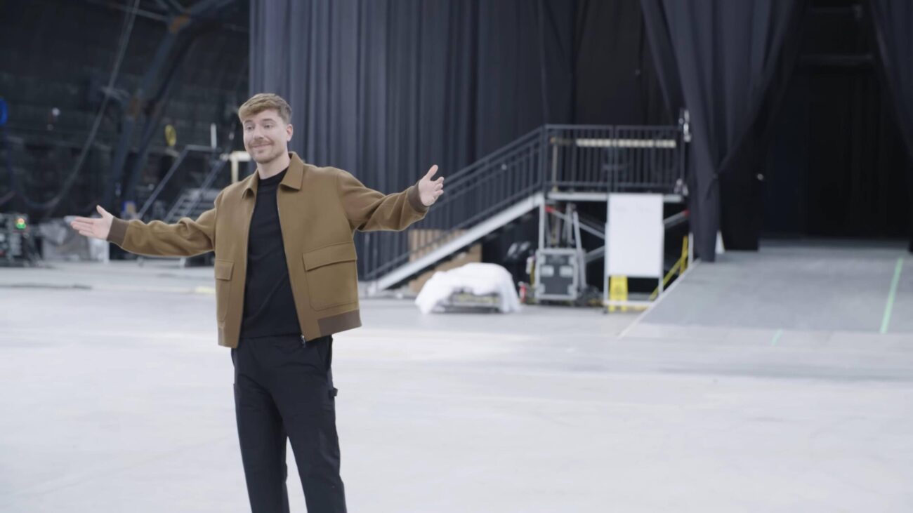 Man standing with open arms inside a large video production studio.
